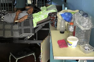 Containers filled with water are seen next to the bed of a patient at the Central University of Venezuela (UCV) hospital in Caracas, Venezuela  